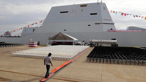 In this Oct. 13, 2016 photo, a worker prepares for a commissioning ceremony for the future USS Zumwalt, back, the U.S. Navy's newest guided-missile destroyer, in Baltimore. The destroyer's commissioning ceremony is set for Oct. 15 during the inaugural Maryland Fleet Week. (AP Photo/Patrick Semansky)