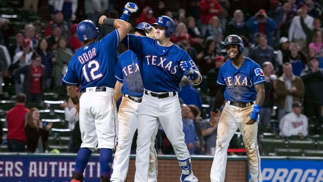 Texas Rangers first baseman Ryan Rua (middle) and second baseman Rougned Odor (left) and left fielder Delino DeShields (right) celebrate Rua hitting his first career grand slam during the eighth inning against the Minnesota Twins at Globe Life Park in Arlington. Mandatory Credit: Jerome Miron-USA TODAY Sports