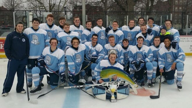 Livonia Stevenson's hockey team poses with its 'Frozen Fish Fiasco' trophy Sunday afternoon.