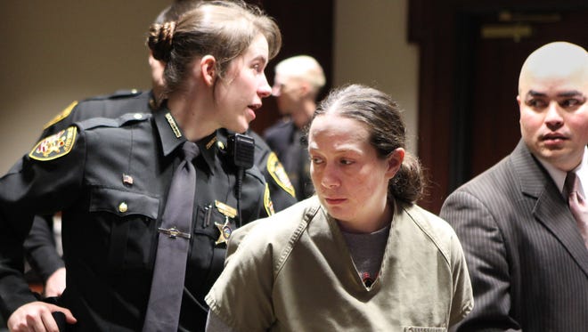 A Hamilton County deputy sheriff takes April Corcoran from the courtroom after she was arraigned on 27 felony charges Thursday -- including complicity to rape, for allegedly trading her 11-year-old daughter for heroin in exchange for sex.