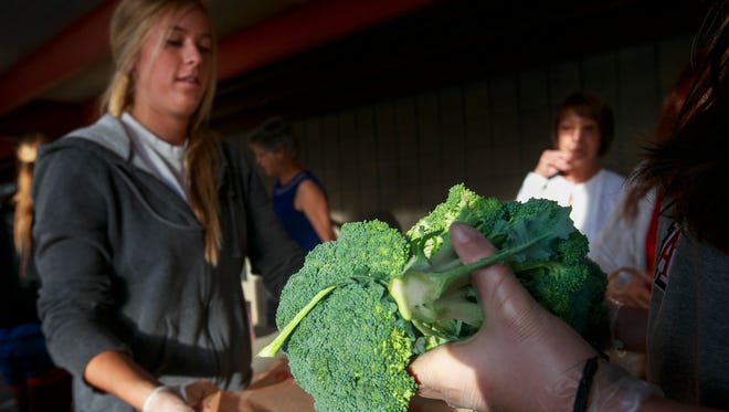 Julia Osborne bags some broccoli at the St. Mary’s Food Bank Alliance mobile pantry in 2012.