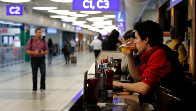 In this photo from Feb. 24, 2017, traveler Dominic Maley sips on a beer while waiting to board a flight at St. Louis Lambert International Airport.