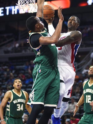 Pistons guard Kentavious Caldwell-Pope (5) is fouled by Bucks forward John Henson (31) during the second quarter of their preseason game Monday at the Palace.