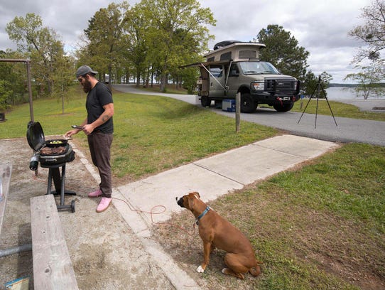 Joe Hawley cooks steaks for lunch with his dog Freedom