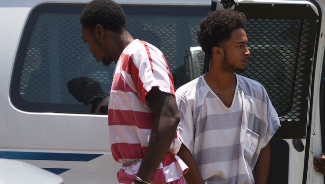 James Malik Windham, left, and Demethius K. Dixon walk to the Hattiesburg Police Department for their first appearance at the Hattiesburg Municipal Court on Monday. Windham and Dixon were arrested early Monday and charged in connection to the murder of Corey Husband. 