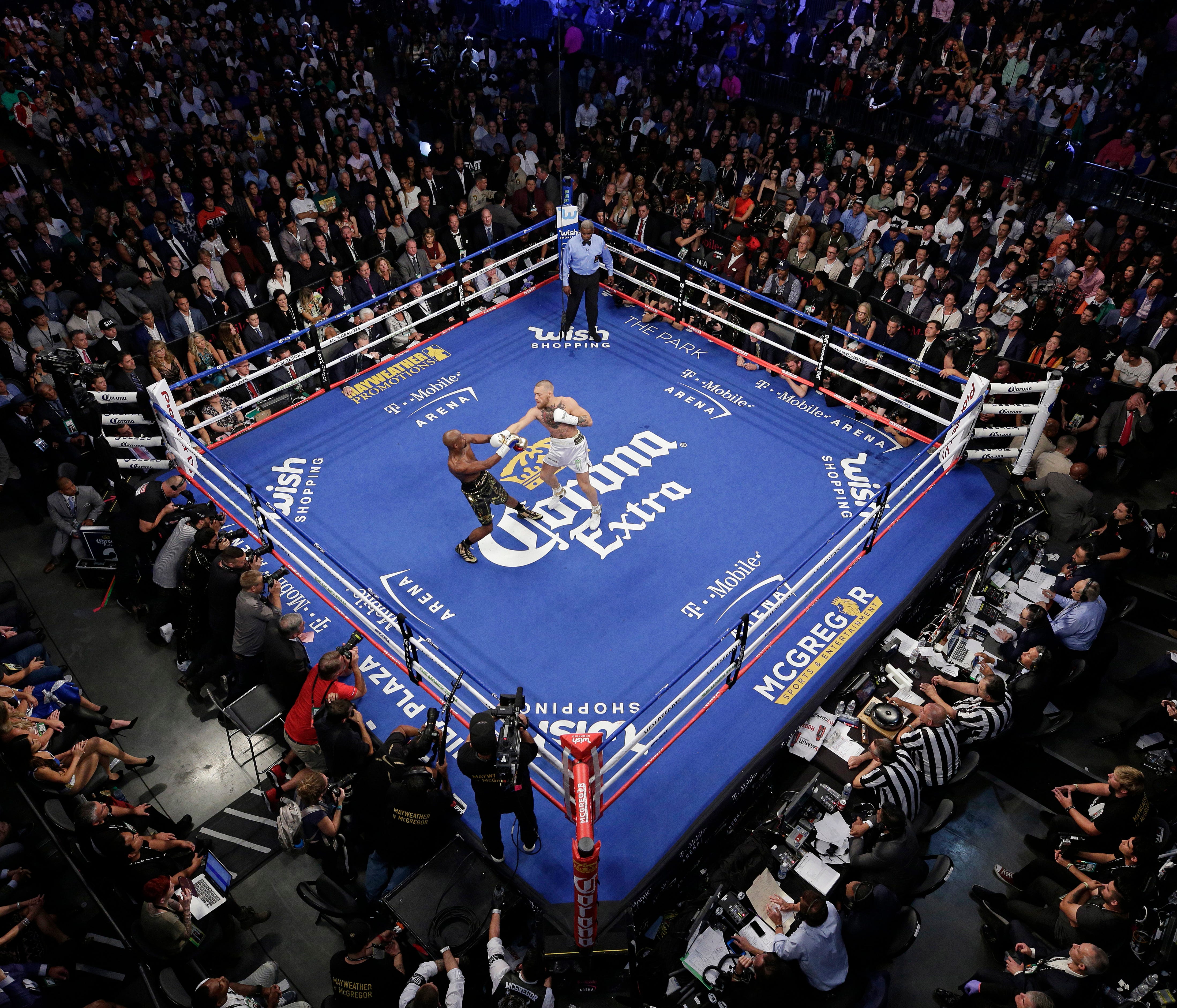 Floyd Mayweather Jr., left, fights Conor McGregor in a super welterweight boxing match Saturday, Aug. 26, 2017, in Las Vegas. (AP Photo/Eric Jamison) ORG XMIT: NVJL217