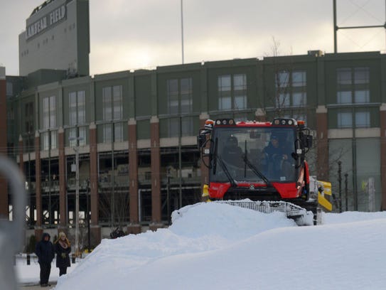 Workers prepare the Ariens Hill snow-tubing run in