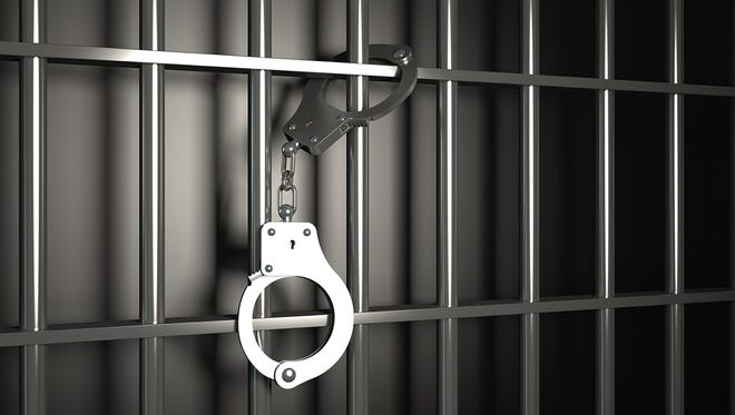 Prison bars with handcuffs.