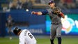 U.S. second baseman Ian Kinsler, right, relays to first