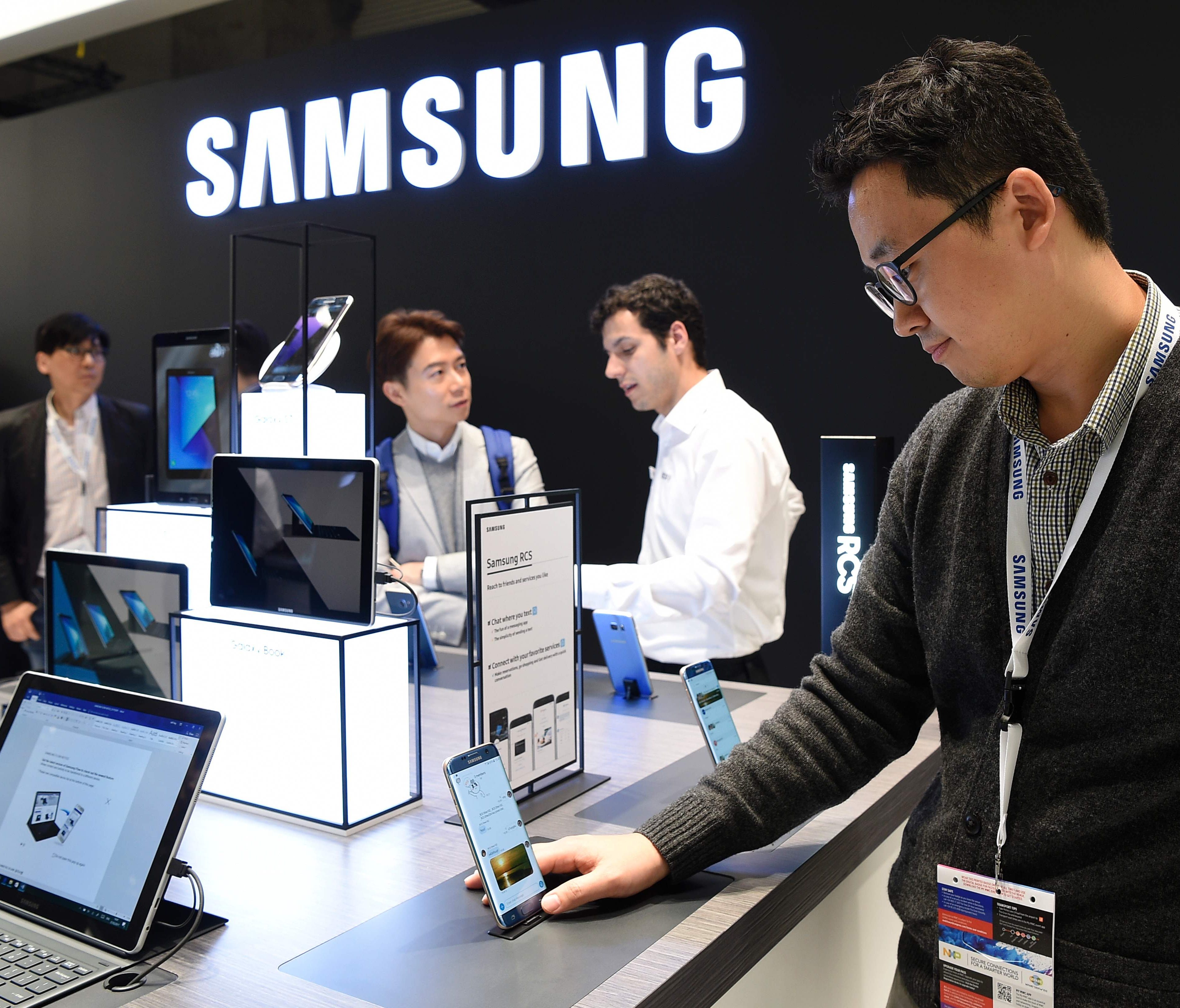 Visitors try devices at the stand of Samsung on the first day of the Mobile World Congress in Barcelona.
