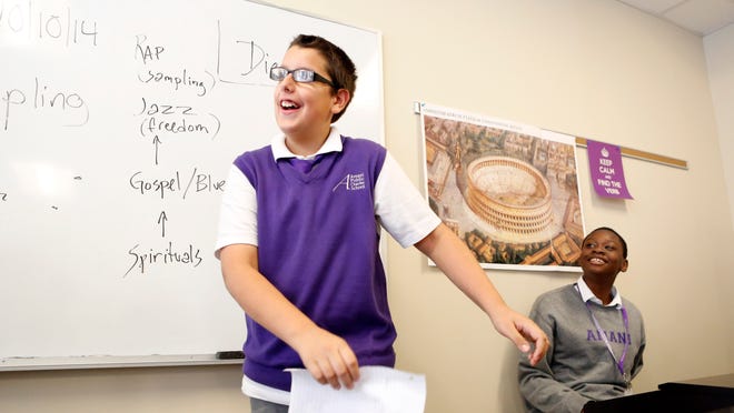 Seventh-graders Jesus Pujols and Shemani Fuller laugh while rapping in music class at Amani Public Charter School in Mount Vernon. Amani has a longer school day than traditional public schools, 7:50 a.m. to 3:30 p.m., with double classes of math and English language arts.