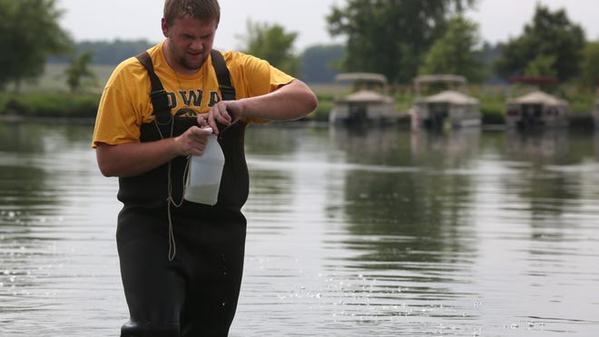Chas Cahill collects a sample of water from Big Creek Lake in Polk City this week.