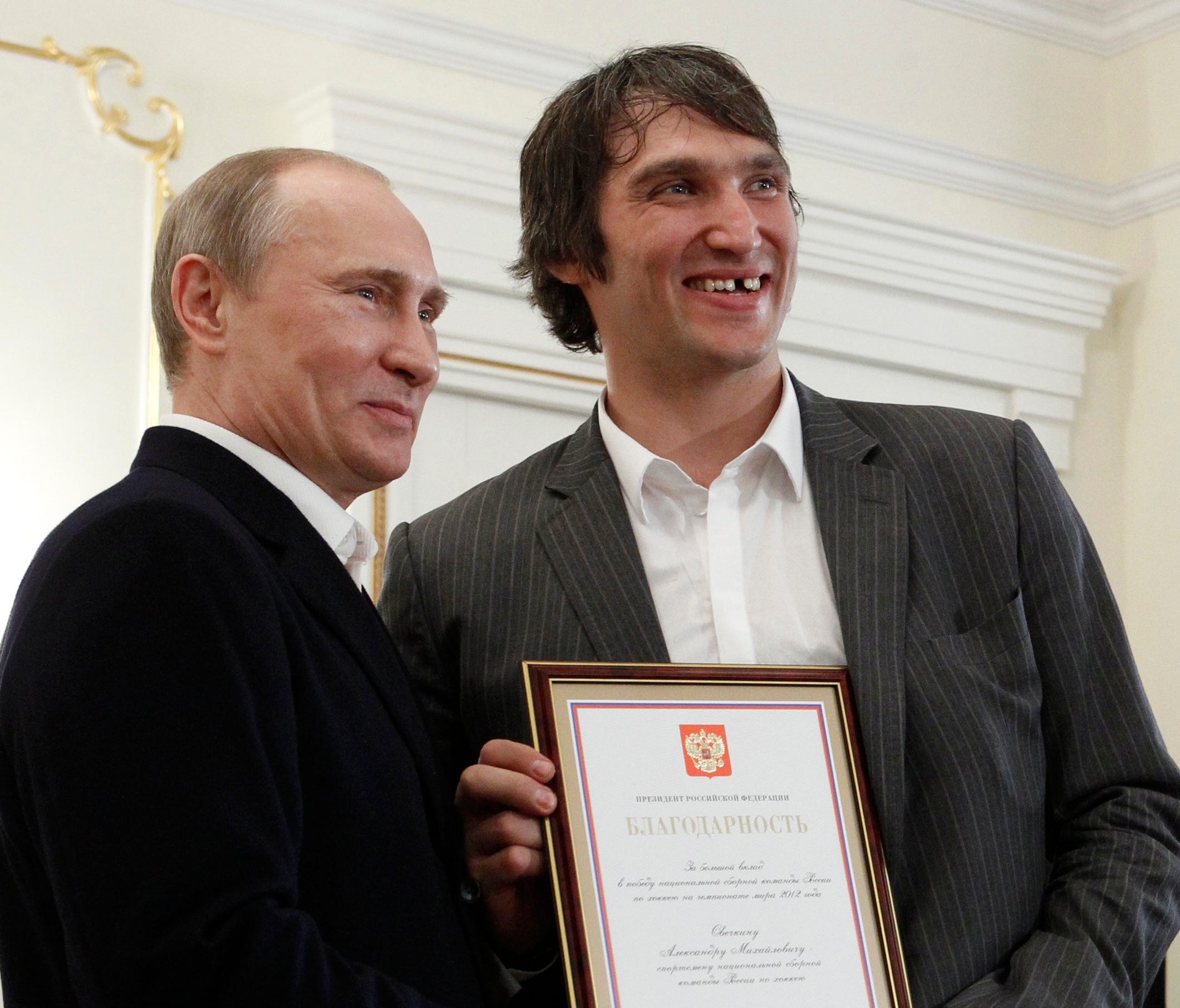 FILE - In this May 29, 2012, file photo, Russian national ice hockey team member Alexander Ovechkin, right, holds a certficate of recognition given to him by President Vladimir Putin, left, in the Novo-Ogaryovo residence outside Moscow. Washington Ca