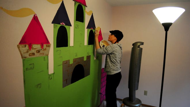 
Melanie McKeefry, of Special Spaces, creates a mural with a princess theme, during the dream bedroom makeover for Becca Connelly, who along with brother, Evan, suffers from Fanconi anemia on Saturday. 
