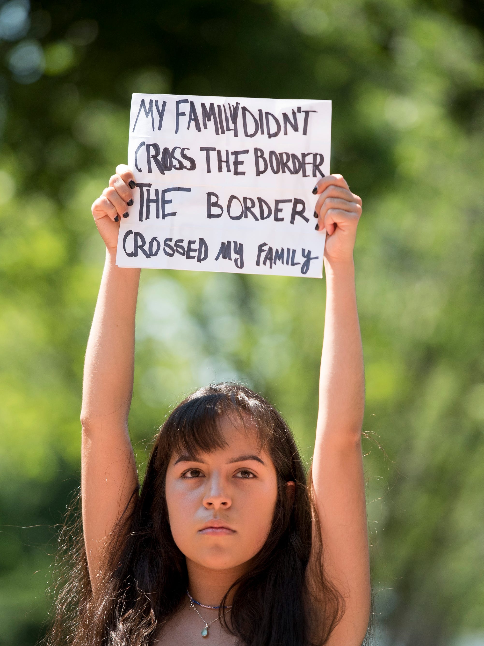 Vanessa Luna, 17, holds a sign during the Families