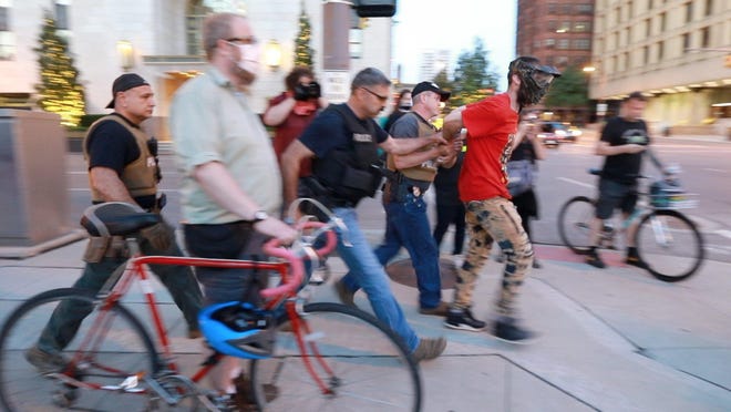 Columbus Police arrest Ronnie Earl Murdock Jr., in the red shirt, on June 24.
