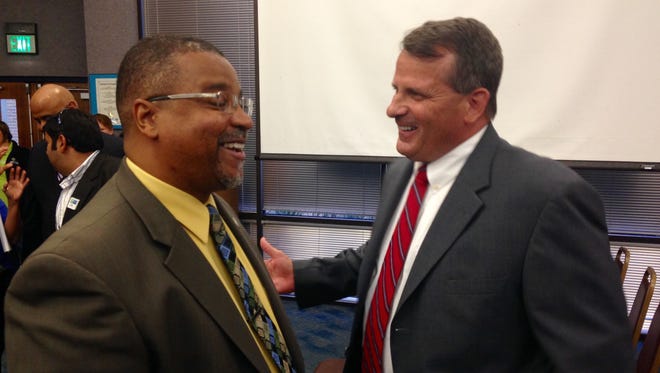 Palm Bay Mayor William Capote chats with new city manager, Gregg Lynk, at Tuesday's City Council meeting.