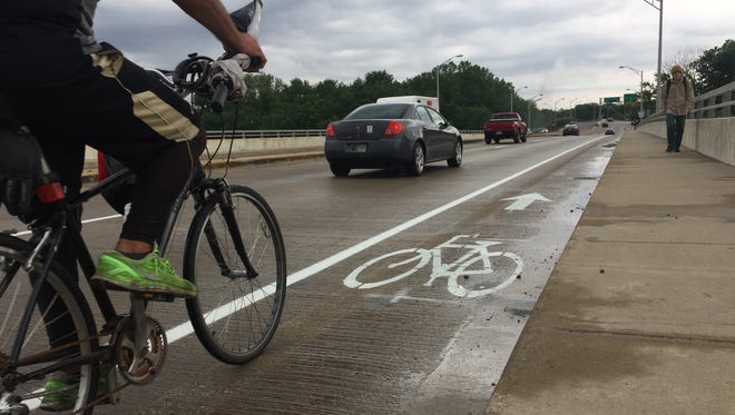 A cyclist rides on Harrison Bridge's new, wider bike lanes on his way from West Lafayette to Lafayette.