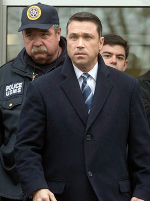 File-This Dec. 23, 2014, file photo shows Rep. Michael Grimm, center, leaving Federal court in Brooklyn after pleading guilty to a federal tax evasion charge rather than go to trial in New York. A Republican source says the New York congressman is expected to resign before Congress returns to Washington next week. Following his conviction, Republican Congressman Michael Grimm had said he would stay in Congress as long as he could. But Grimm reportedly talked with House Speaker John Boehner Monday, Dec. 29, 2014, and will instead step down. (AP Photo/John Minchillo, File)