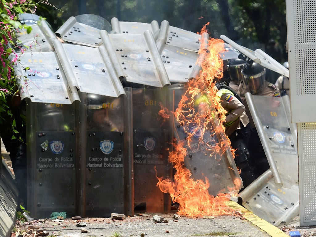 A Molotov cocktail explodes against the shields of riot police during a protest against the Venezuelan government by students of the Central University of Venezuela in Caracas.