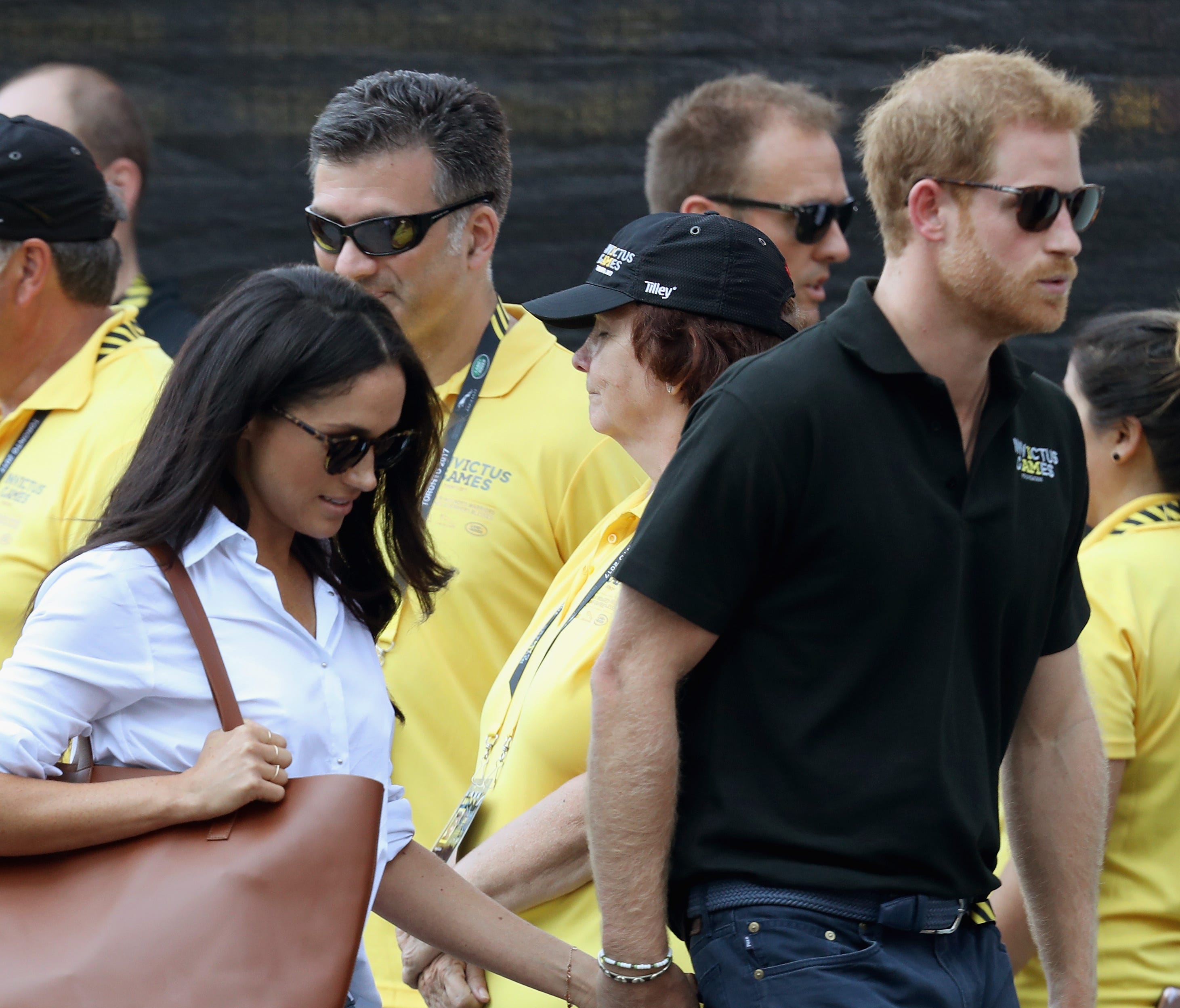 Prince Harry and girlfriend Meghan Markle hold hands as they arrive for wheelchair tennis match at Invictus Games in Toronto, Sept. 25, 2017.