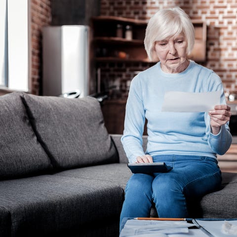 Older lady sitting on couch with Social Security c