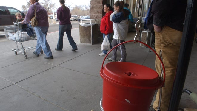 In this Coloradoan file photo, shoppers at Albertson's on North College Avenue pass a Salvation Army bell ringer.