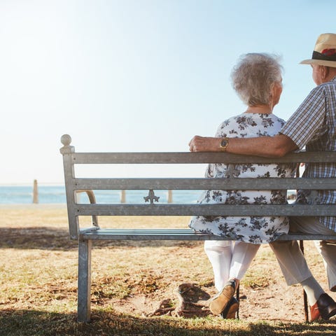 Senior couple sitting on a bench at the beach