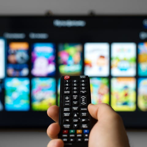 Man pointing remote at a TV