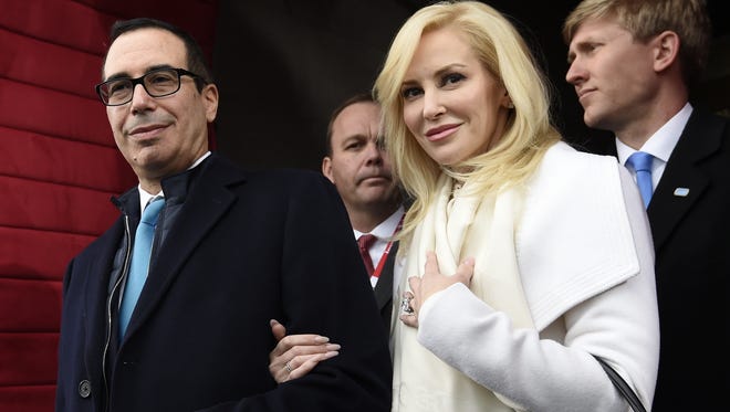 In this Friday, Jan. 20, 2017, file photo, then Treasury Secretary-designate Stephen Mnuchin and his then-fiancee, Louise Linton, arrive on Capitol Hill in Washington, for the presidential inauguration of Donald Trump. Linton responded to a social media critic on Aug. 21, 2017, telling the mother of three that that she was “adorably out of touch.” Mnuchin and Linton were married in June. (