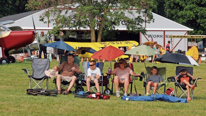 A family sets up early along the flight line so they can get front row seats to watch the Thunderbirds during the air show at AirVenture 2014.