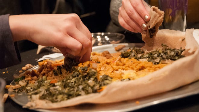 Food was served on a large platter of Injera, a spongy bread topped with chicken and beef stews, lentils and greens. More Injera was used to scoop up the food in the family-style setting.