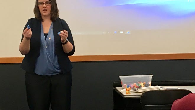 Michelle Trent, associate director of The Compass Center, uses LEGOs to demonstrate how a survivor of a traumatic event might stash away unpleasant memories in their minds.