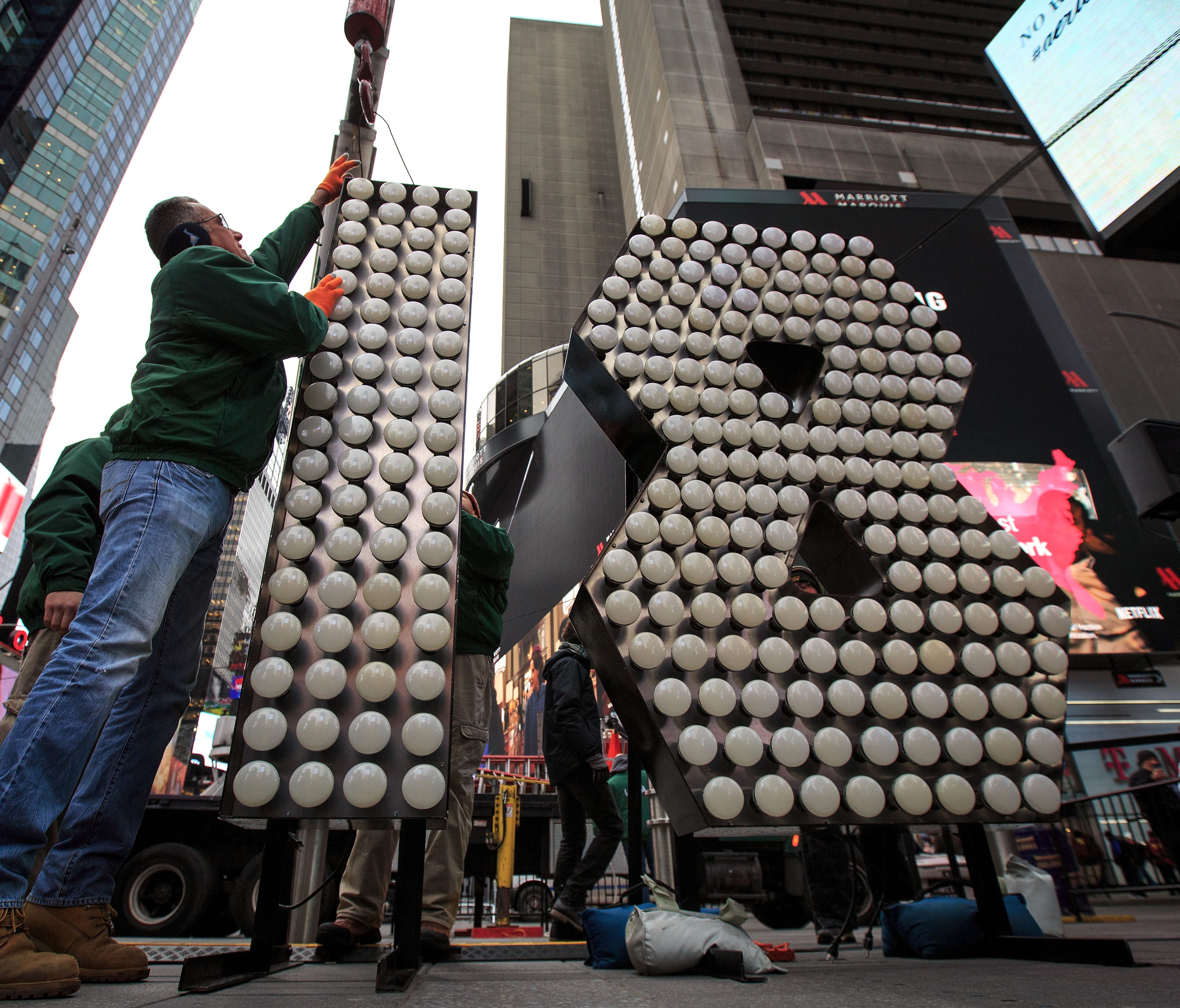Workers unload the numerals 1 and 8 as they arrive in Times Square ahead of the New Year's Eve celebration.