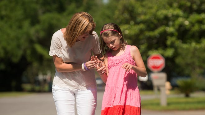 
Holley Moseley, 11, and her daughter RayAnn walk to the park in their neighborhood in Gulf Breeze, Fla. RayAnn, who is severely epileptic, was as an inspiration for Florida's Legislature’s change on a bill that will soon allow parents to treat their epileptic children with marijuana that has a low amount of THC, the chemical that causes intoxication. 
