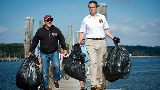 Singer Billy Joel and New York State Gov. Andrew Cuomo, right, carry trash from the beach cleanup at Oyster Bay, N.Y., at the annual beach cleanup at Theodore Roosevelt Memorial Park on Saturday, Sept 20, 2014. Newsday reports that Cuomo and Joel arrived about 10 a.m. by boat at the park.