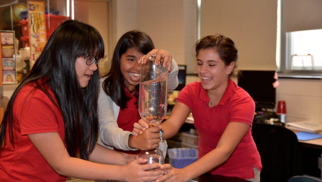 (From left) Sixth graders Shirley Jin, Itzel Herrera and Lianna Isihos, built an individual tornado simulator in Rhonda Hennessy's science class at Veterans Memorial School.