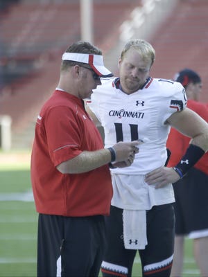 UC quarterback Gunner Kiel talks with  the coaches before the scrimmage.