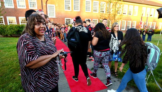 North Salem High School principal Cynthia Richardson greets freshman as they arrive to their first day of high school to a red carpet welcome, Tuesday, September 8, 2015, in Salem, Ore.