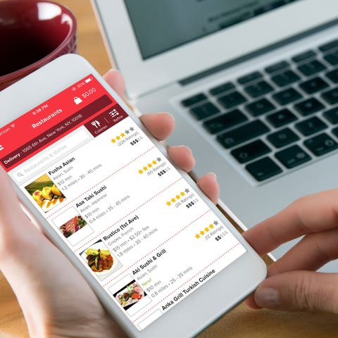 A person holding a smartphone with the Grubhub app
