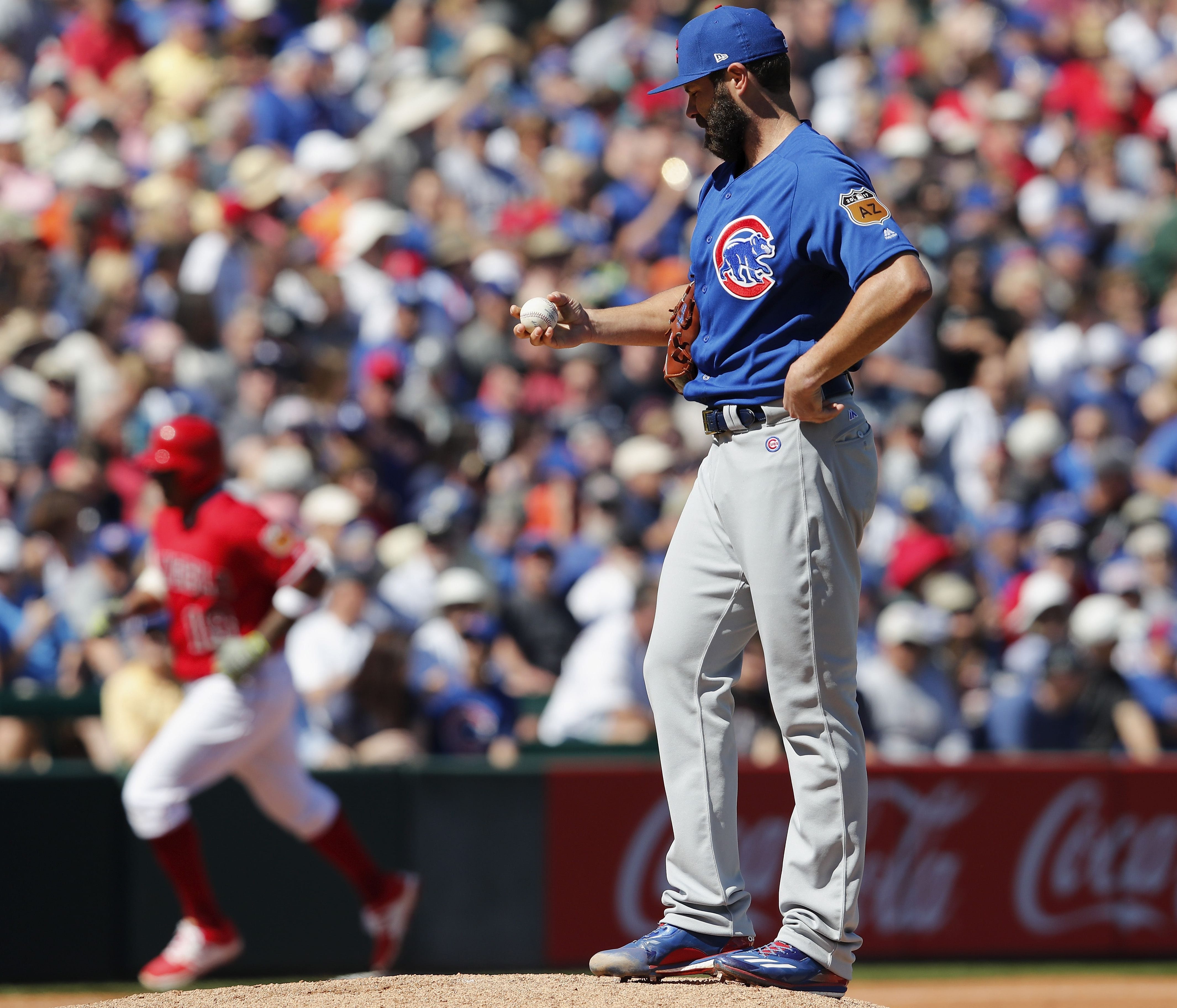 TEMPE, AZ - MARCH 06:  Jake Arrieta #49 of the Chicago Cubs reacts on the mound as Jefry Marte #19 of the Los Angeles Angels rounds third base after a home run in the second inning during the spring training game at Tempe Diablo Stadium on March 6, 2