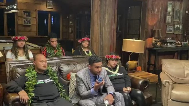 In this still image from video provided by the NFL, Tua Tagovailoa, front center, holds up a phone during the NFL Draft.