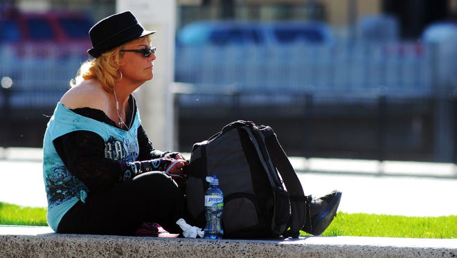 A woman sits outside enjoying the morning sun Thursday at the City Plaza park in downtown Reno. Forecasters said they expect record breaking heat Friday.