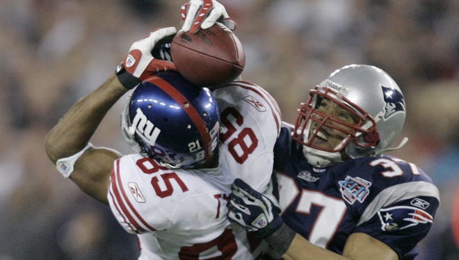 New York Giants receiver David Tyree (85) catches a 32-yard pass in the clutches of New England Patriots safety Rodney Harrison (37) during the fourth quarter of the Super Bowl XLII football game at University of Phoenix Stadium on Sunday, Feb. 3, 2008 in Glendale, Ariz. (AP Photo/Gene Puskar)