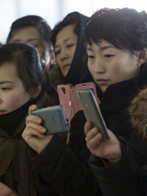 Visitors take smartphone photos at the '8th National Cooking Competition' at the Pyongyang Noodle House in Pyongyang, Feb. 12, 2018.