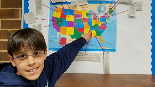 Kevin Jackson, a fourth-grade student at Charlotte Latin School in Charlotte, N.C., points to Tennessee on a U.S. map. Jackson is looking for items that represent the state for a class project.