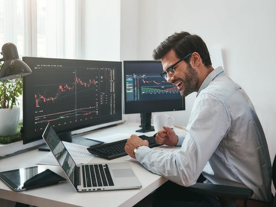 Excited investor looking at stock graph on his computer monitor.