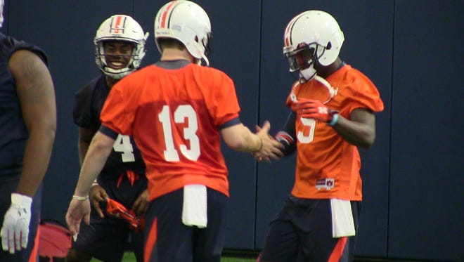 John Franklin and Sean White (13) exchange handshake as Jason Smith laughs during Auburn's first day of practice Wednesday.