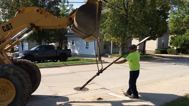 A DPW worker removes a parking sign on Thomas Street.