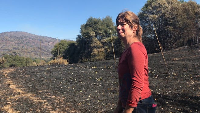 Cassie Taaning-Trotter grows emotional as she walks across her burned property near Redwood Valley, California, on Friday, Oct. 13. Taaning-Trotter lost her home in the wildfires that ripped through a wide swath of Northern California.
